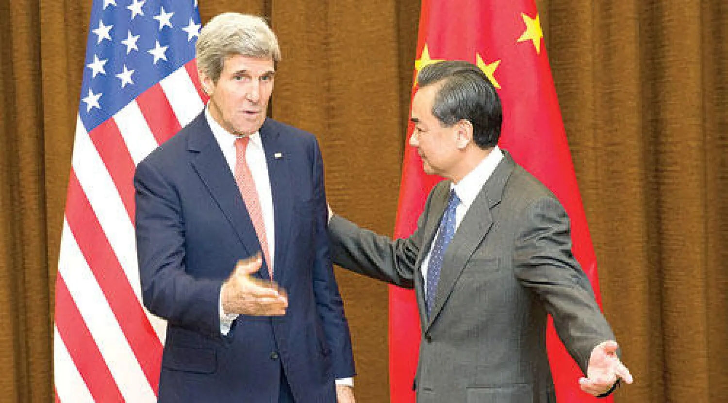 وزير الخارجية الصيني وانغ يي لدى استقباله نظيره الأميركي جون كيري في بكين أمس (أ.ب)