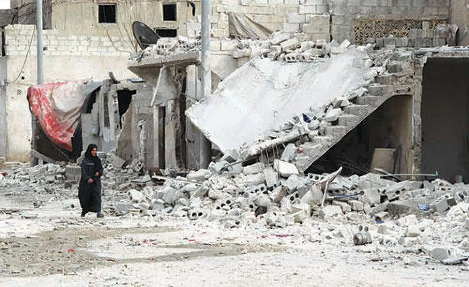 سورية تسير قرب الأنقاض في أحد شوارع مدينة حلب أمس (أ.ف.ب)