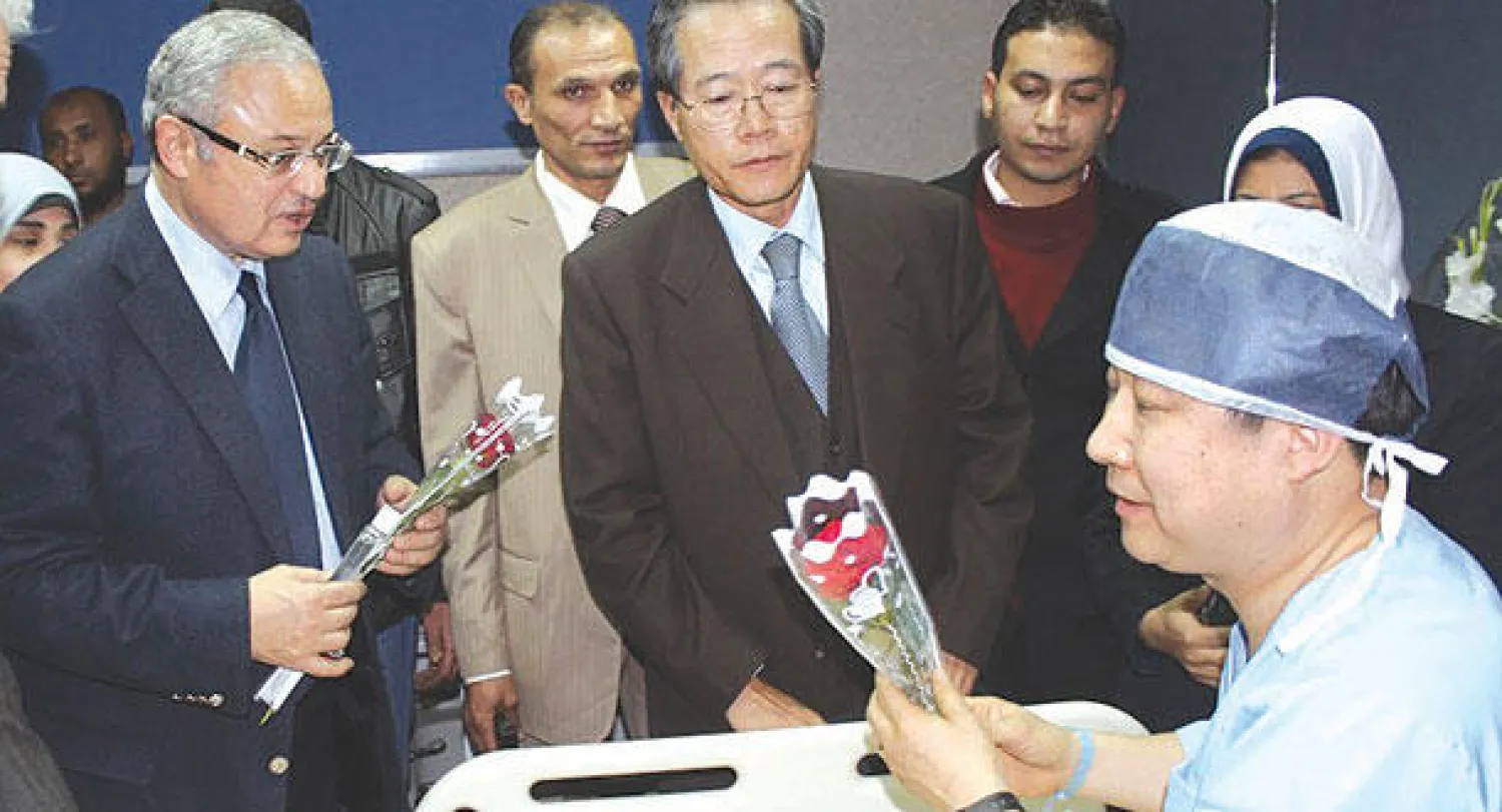 وزير السياحة المصري هشام زعزوع يقدم ورودا إلى أحد المصابين الكوريين  في حادث تفجير الحافلة السياحية بمستشفى شرم الشيخ الدولي أمس (أ.ب)