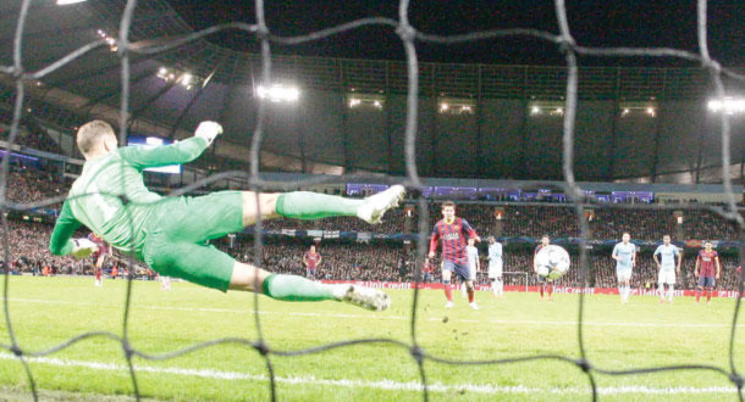 ميسي يخدع هارت خلال تسجيله هدف برشلونة الأول من ركلة جزاء (أ.ب)