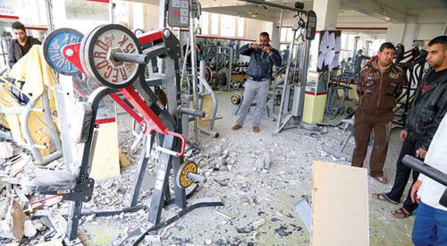 عراقيون يعاينون موقع تفجير ناد رياضي بواسطة قنابل الهاون في قضاء المسيب (جنوب بغداد) أمس (أ.ب)