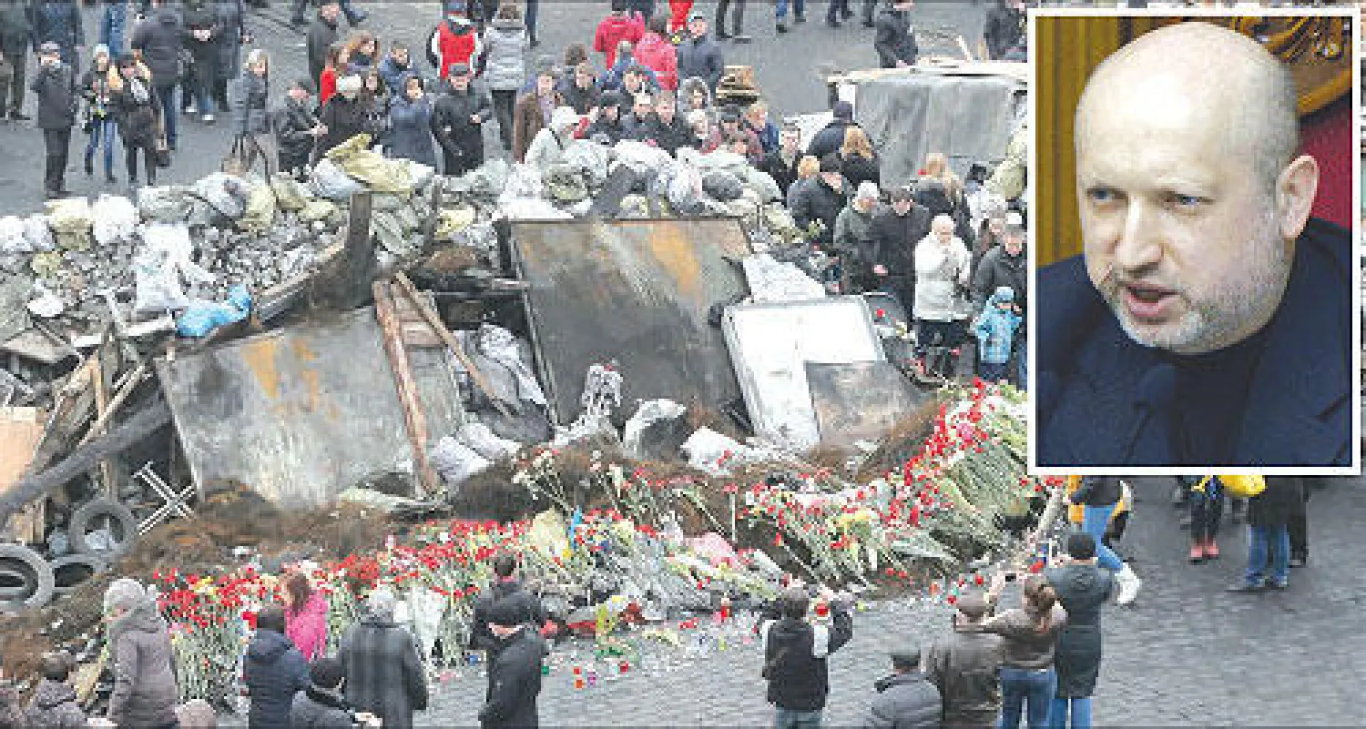 ألكسندر تورتشينوف، و زهور تحيط بحواجز أقامها المتظاهرون في ميدان الاستقلال بكييف أمس (أ.ب)