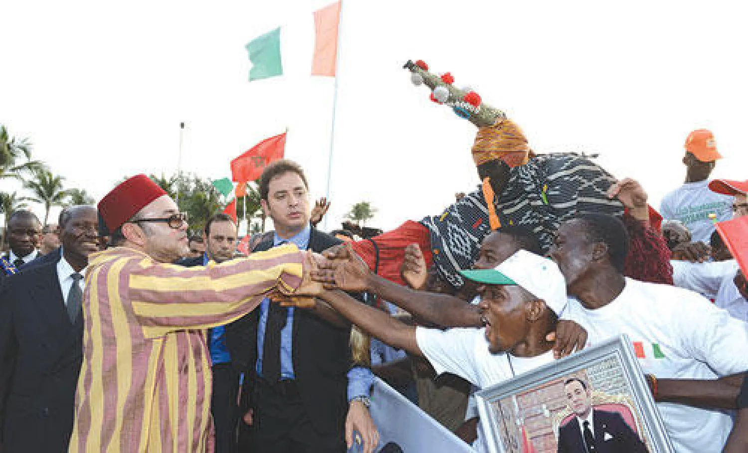 العاهل المغربي يحيي مواطنين إفواريين لدى وصوله إلى أبيدجان أمس (ماب)