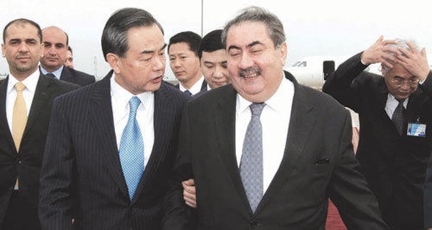 وزير الخارجية العراقي هوشيار زيباري مستقبلا نظيره الصيني وانغ يي في مطار بغداد الدولي أمس (رويترز)