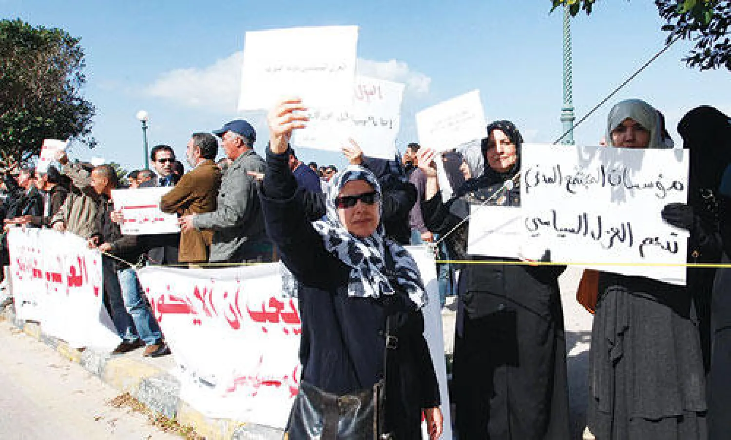 متظاهرون ليبيون يرفعون لافتات تدعو إلى تطبيق العزل السياسي الذي أقره البرلمان العام الماضي خارج المحكمة العليا في طرابلس أمس (رويترز)