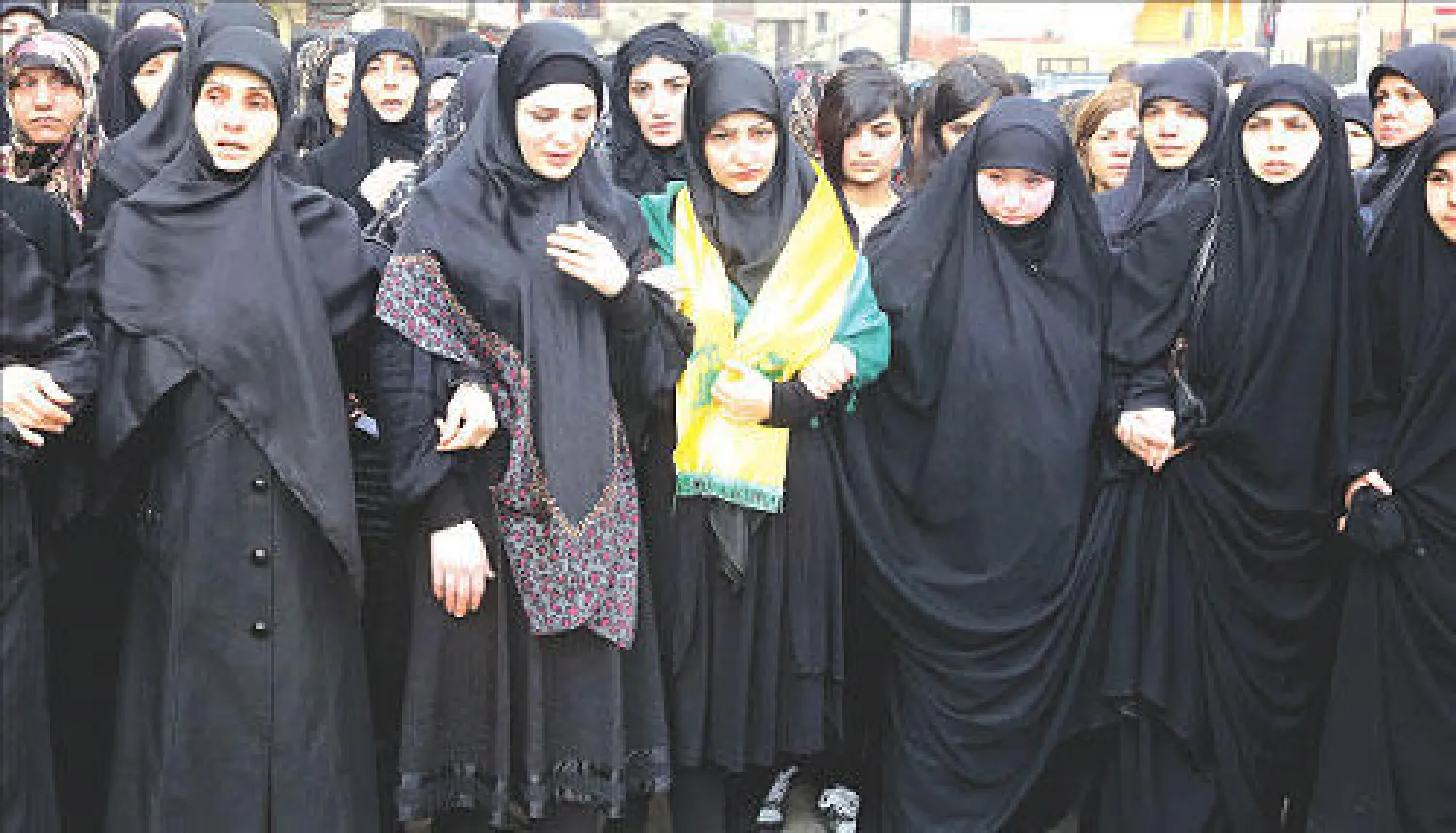 لبنانيات ينتحبن خلال تشييع مقاتل في حزب الله، في ضاحية بيروت الجنوبية، أمس، كان لقي حتفه في سوريا (أ.ف.ب)