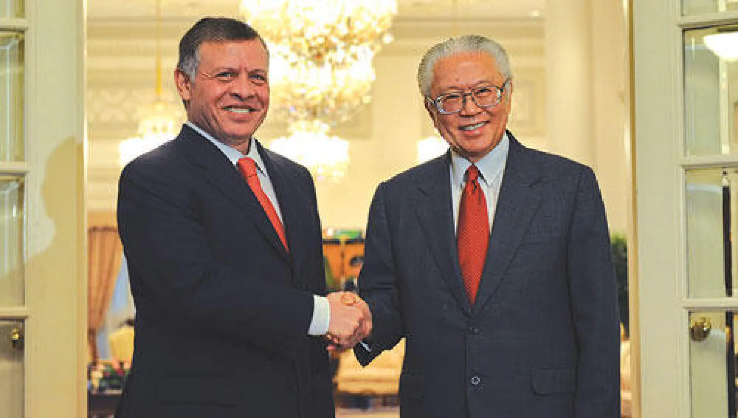 العاهل الأردني الملك عبد الله الثاني خلال لقائه الرئيس السنغافوري توني تان كينغ يام في سنغافورة أمس (أ.ف.ب)