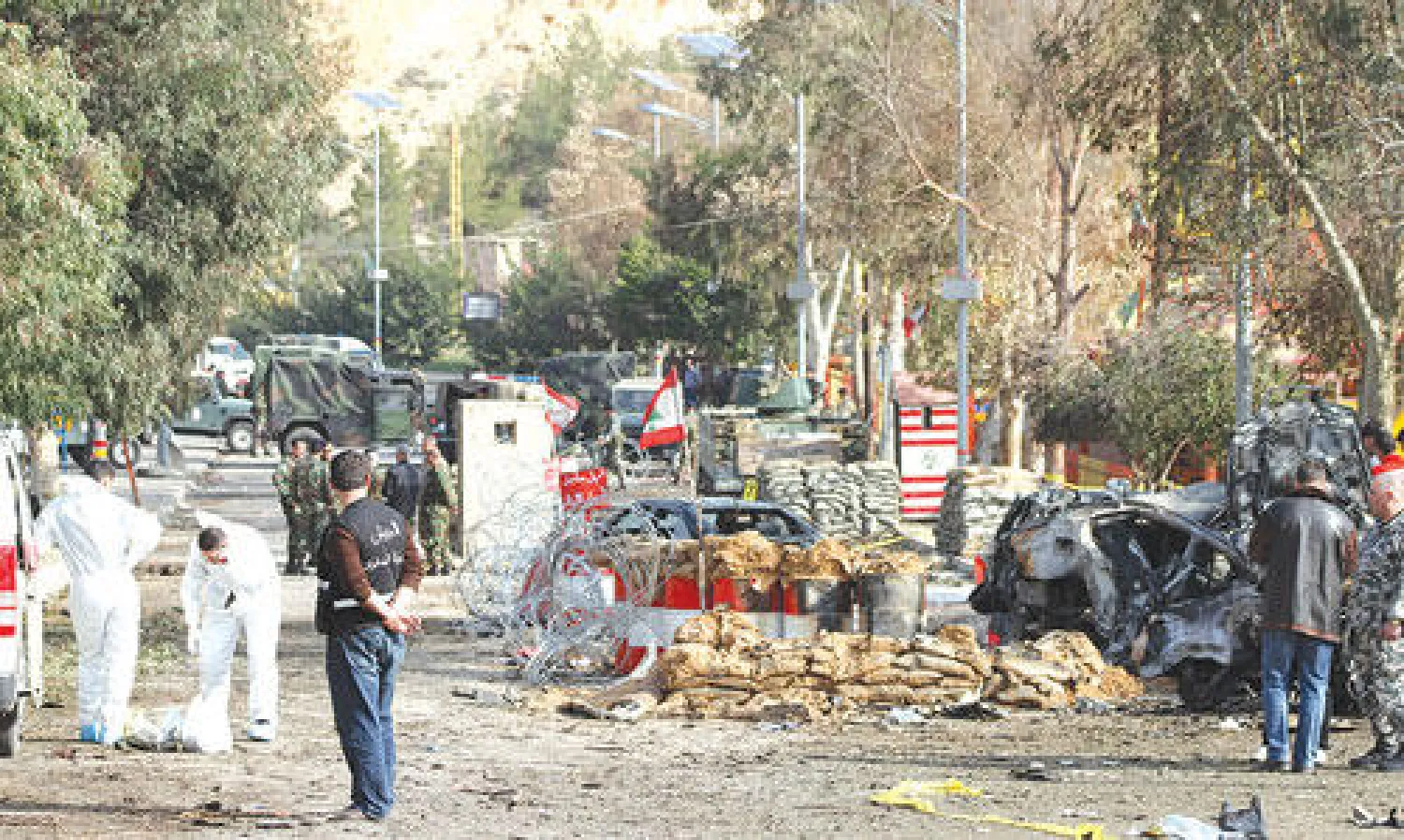 خبراء الأدلة الجنائية اللبنانيون يعاينون أمس موقع تفجير بسيارة مفخخة استهدف أول من أمس نقطة تفتيش في الهرمل بوادي البقاع اللبناني  (أ.ف.ب)