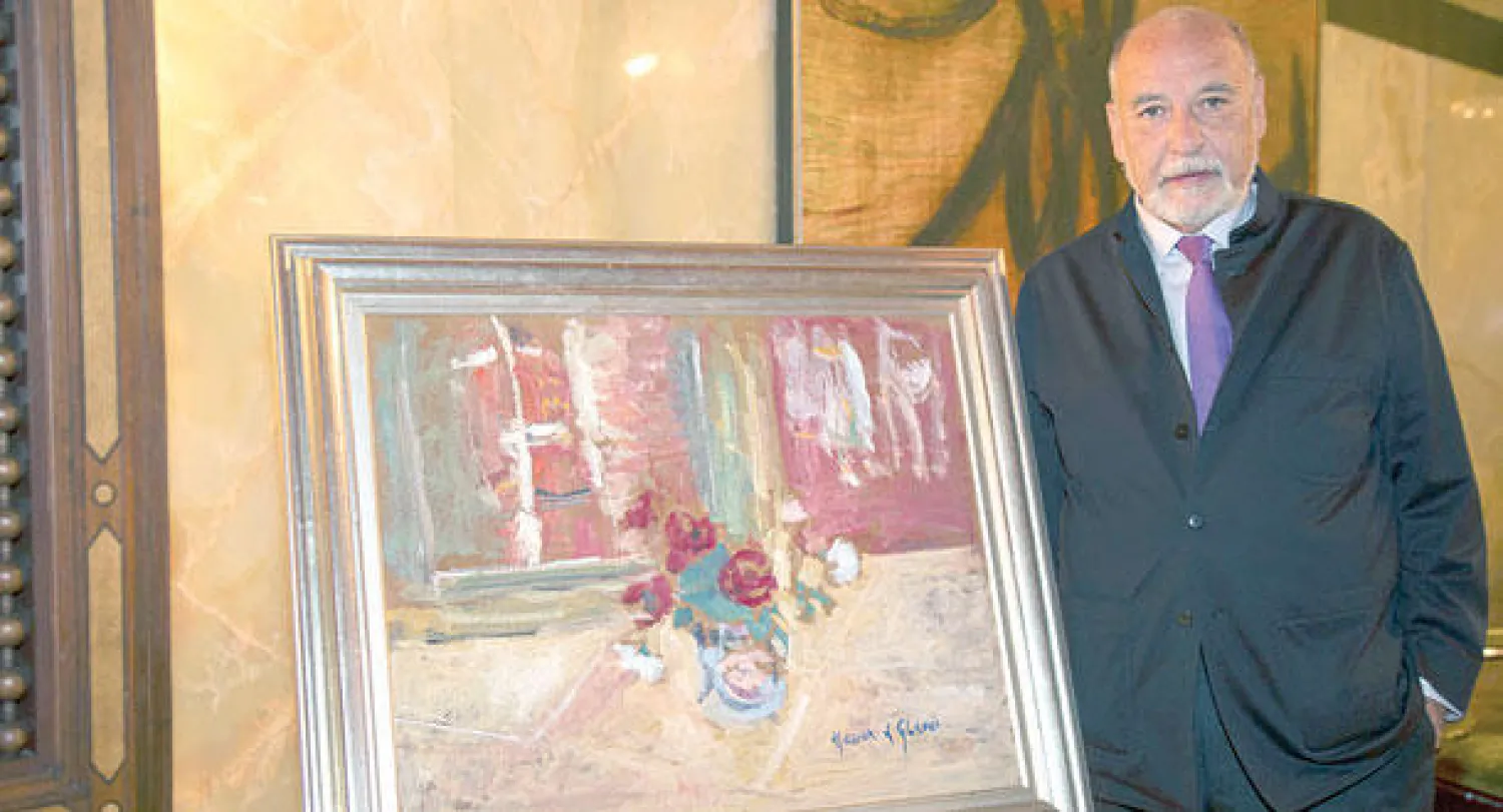 الطاهر بن جلون بجانب لوحة للفنان التشكيلي المغربي حسن الكلاوي، خلال لقاء بمراكش («الشرق الأوسط»)