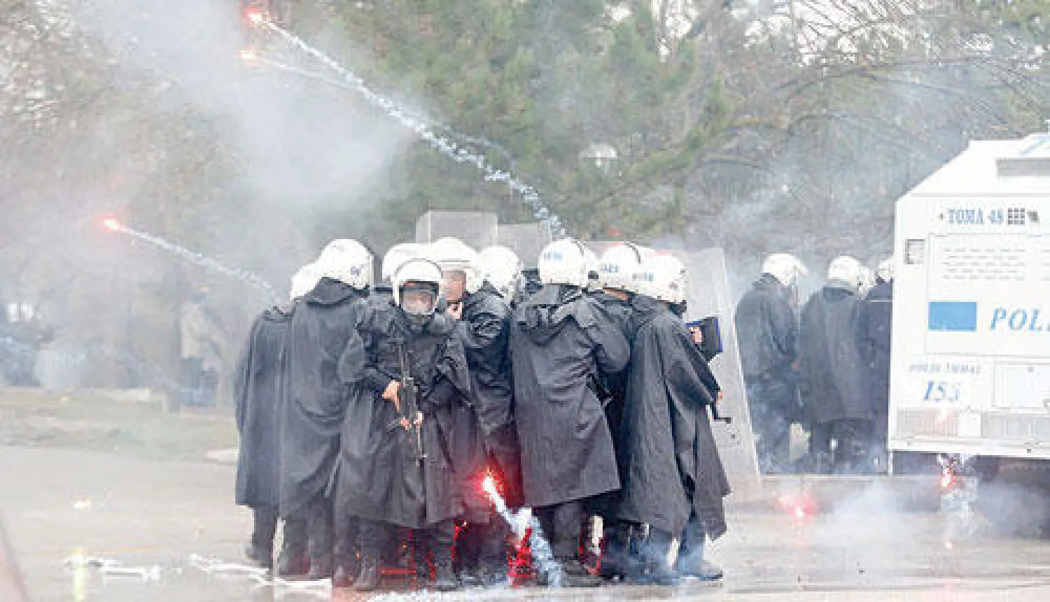 أفراد في شرطة مكافحة الشغب التركية يحاولون الاحتماء من ألعاب نارية (مفرقعات) هاجمهم بها طلاب في احتجاجات ضد فتح طريق في كلية في جامعة الشرق الأوسط التقنية في أنقرة أمس (رويترز)