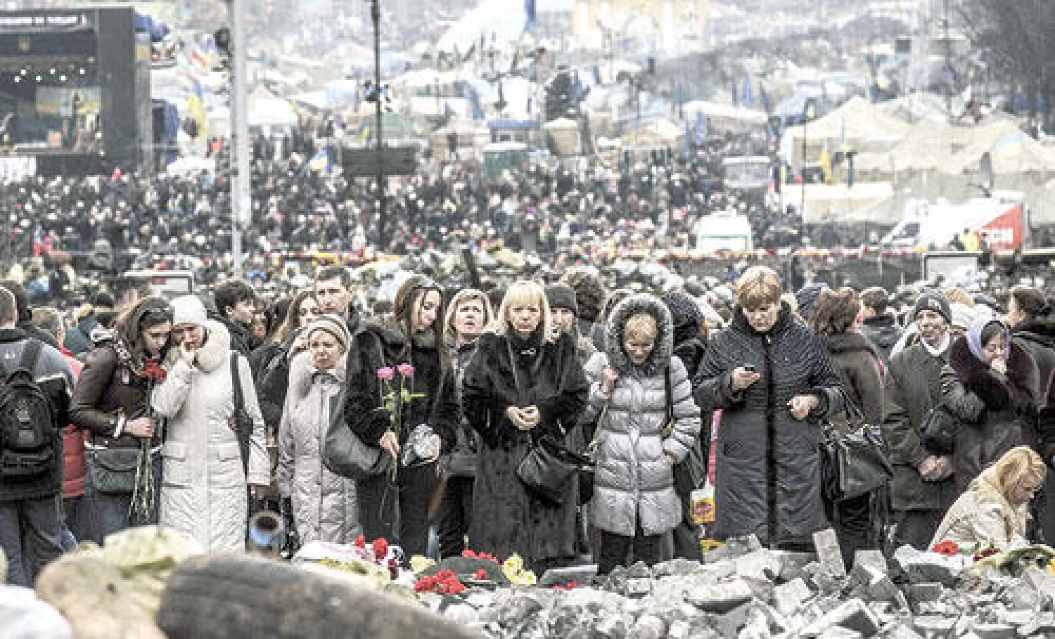 أوكرانيون يزورون ميدان الاستقلال بكييف أمس إحياء لذكرى  ضحايا الاحتجاجات التي شهدتها البلاد اخيرا (أ.ف.ب)