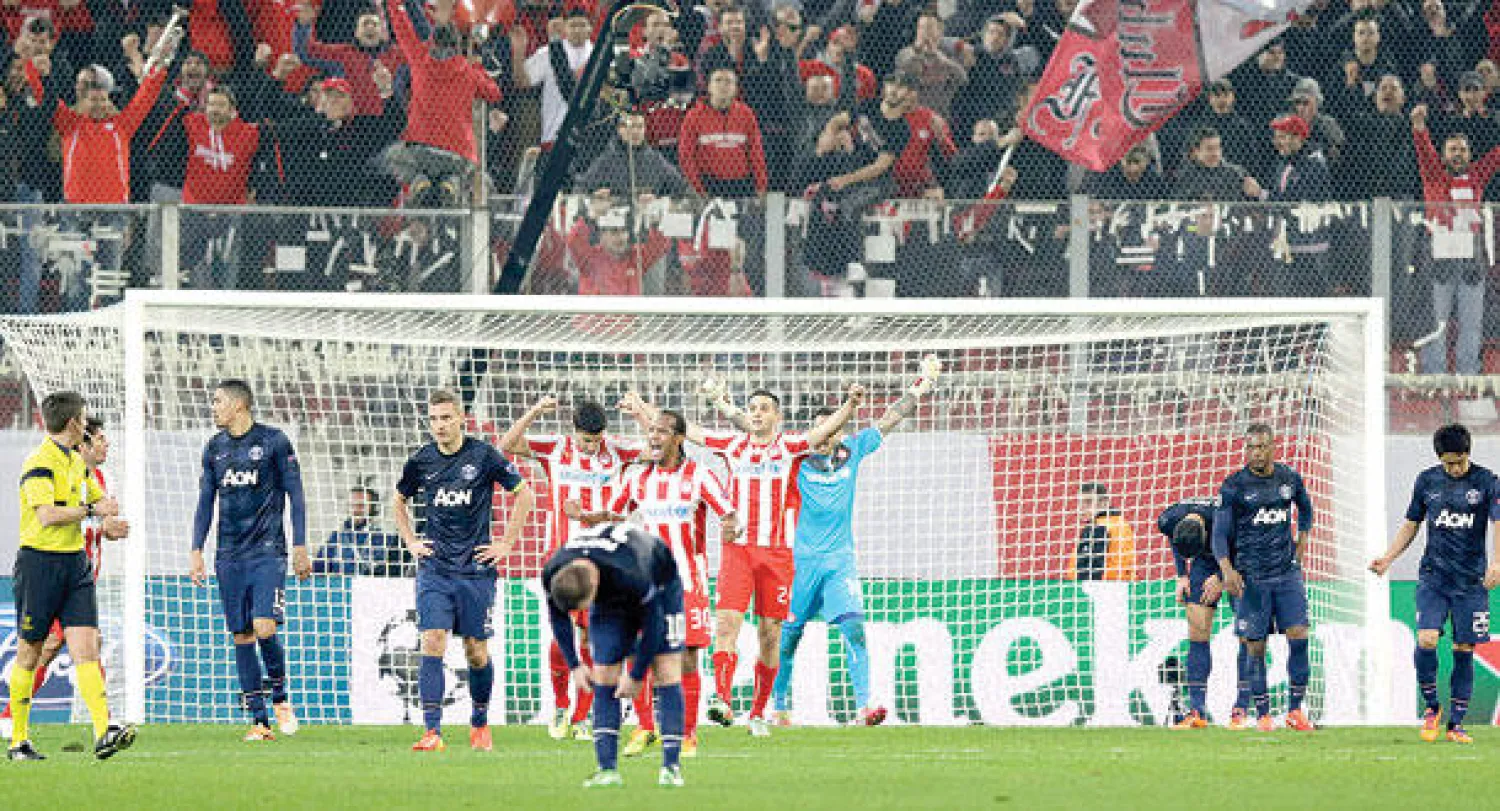 أفراح نجوم أولمبياكوس وأحزان لاعبي يونايتد عقب إطلاق صافرة النهاية (أ.ب)