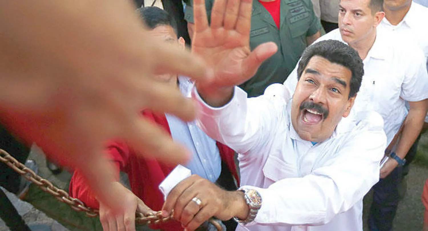 مادورو يحيي أنصاره لدى وصوله للمشاركة  في تجمع بالعاصمة كراكاس مساء أول من أمس (رويترز)