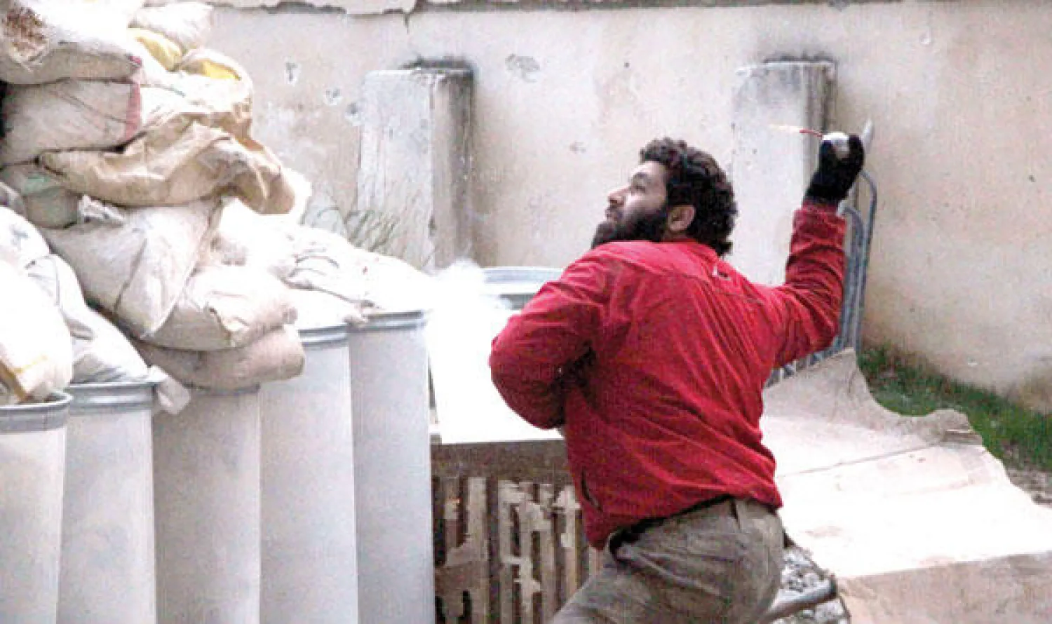 مقاتل في المعارضة يلقي قنبلة على قوات موالية للنظام السوري خلال اشتباكات في مدينة حلب أمس (أ.ف.ب)