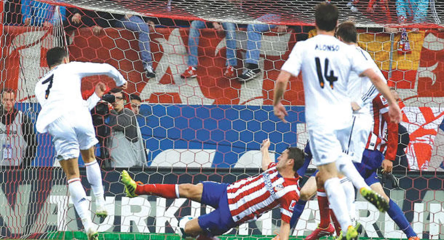 رونالدو نجم ريال مدريد (يسار) يسدد في شباك أتليتكو ليمنح فريقه نقطة التعادل (رويترز)