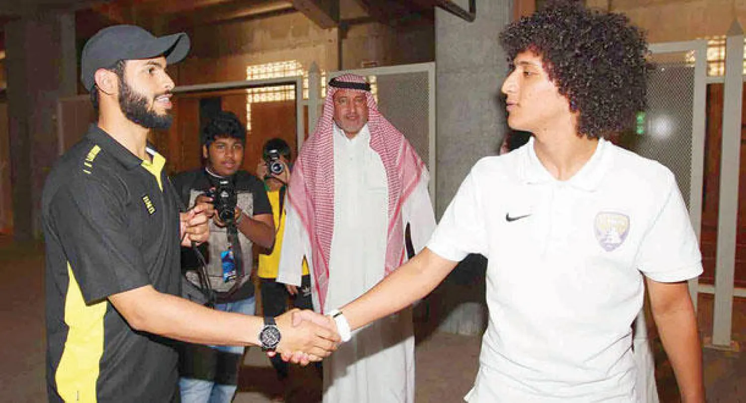 لاعب الاتحاد أحمد الفريدي مصافحا نظيره في العين الإماراتي عمر عبد الرحمن قبل المؤتمر الصحافي (تصوير: عبد الله بازهير)