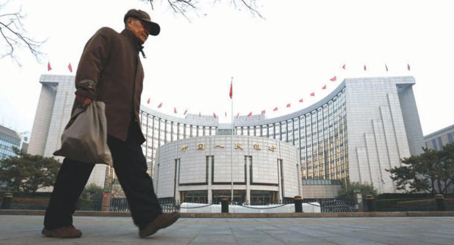 صيني يمر أمام البنك المركزي الصيني في بكين (أ.ب)