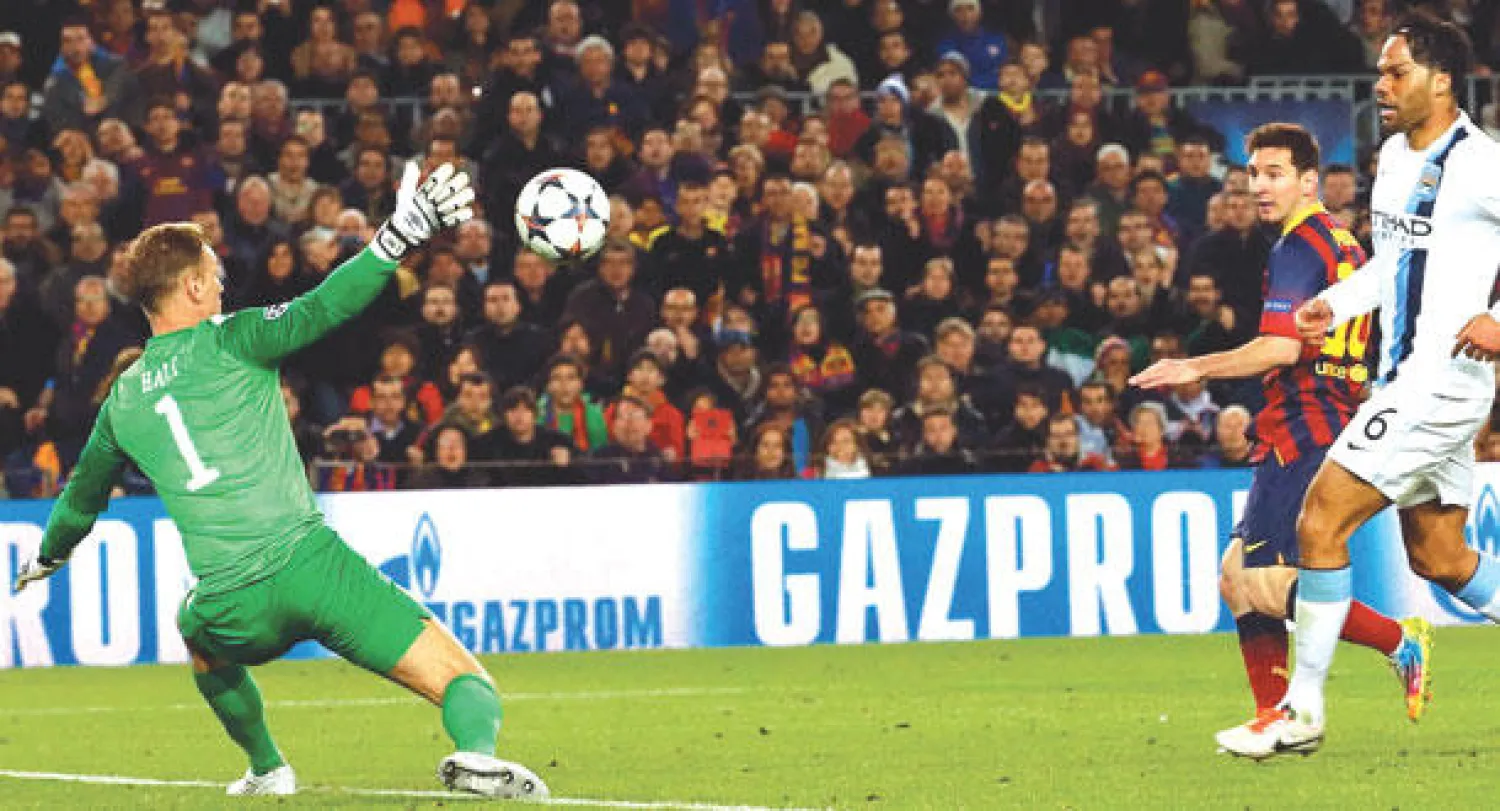 ميسي نجم برشلونة (في الوسط) يسدد من فوق هارت حارس سيتي ليحرز هدف فريقه الأول (رويترز)