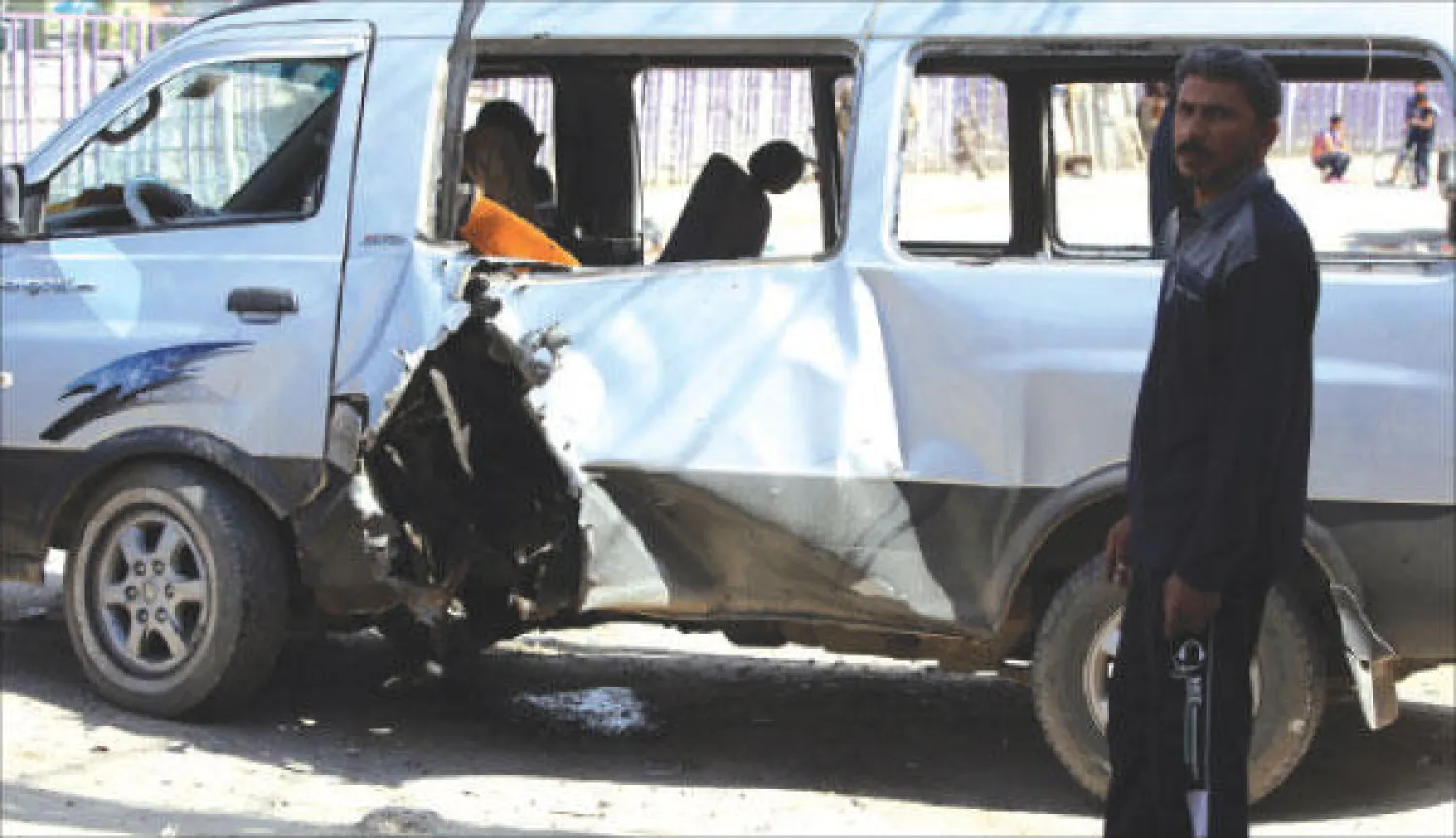 عراقي يقف قرب سيارة انفجرت أمس في مدينة الصدر شرق بغداد (أ.ف.ب)