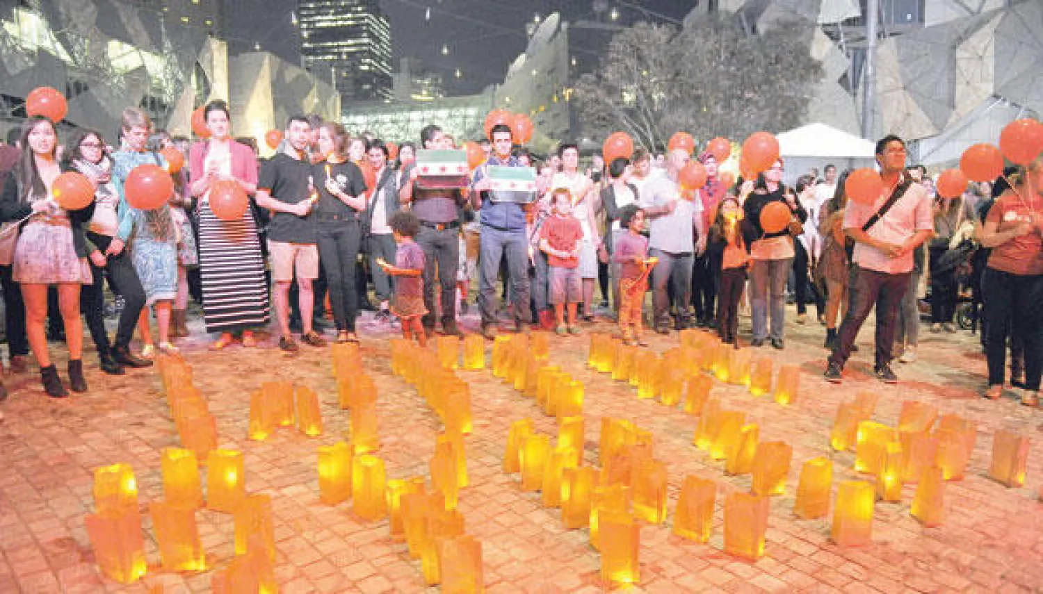 تجمع تضمن إيقاد شموع في الذكرى الثالثة للثورة السورية في ملبورن بأستراليا أمس (أ.ف.ب)