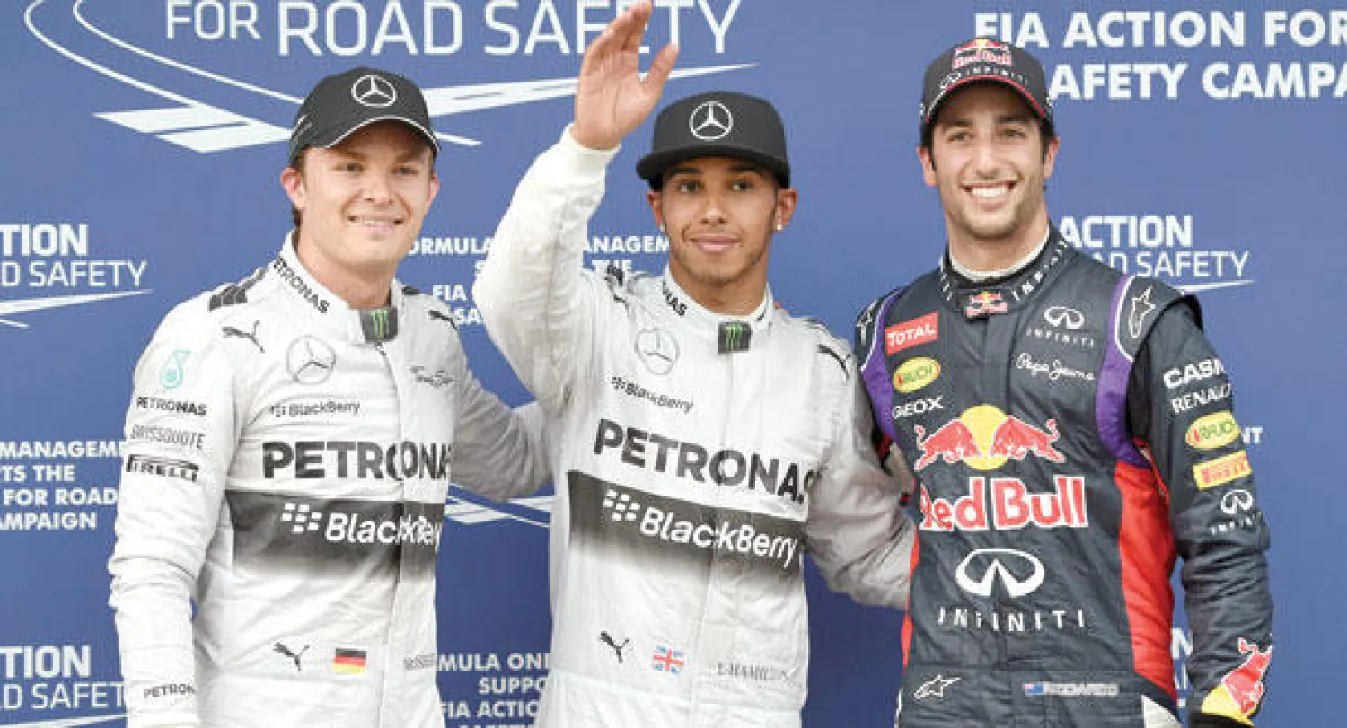 البريطاني هاميلتون سائق فريق مرسيدس يتوسط زميله الألماني وزبرغ (يسار) والأسترالي ريكياردو قائد ريد بول (أ.ب)