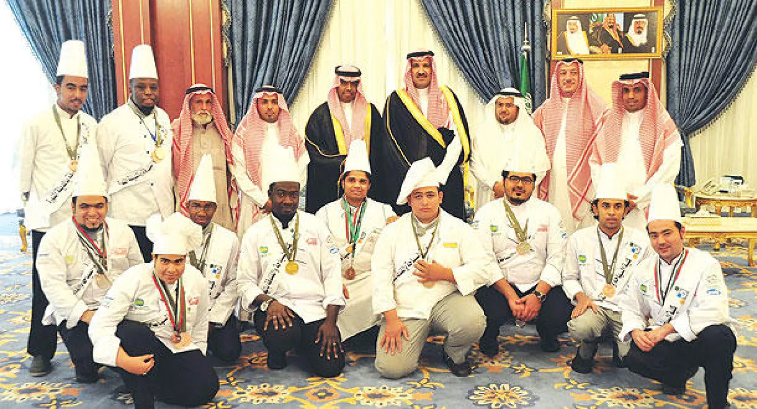 الأمير فيصل بن سلمان يتوسط المكرمين من خريجي كلية السياحة والفندقة