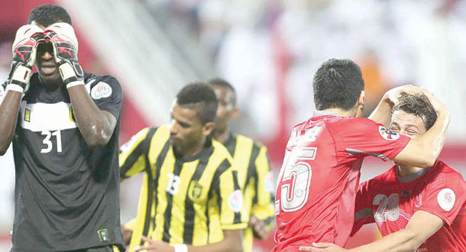 لاعبو لخويا القطري يحتفلون بأحد أهدافهم وسط حسرة الحارس الاتحادي