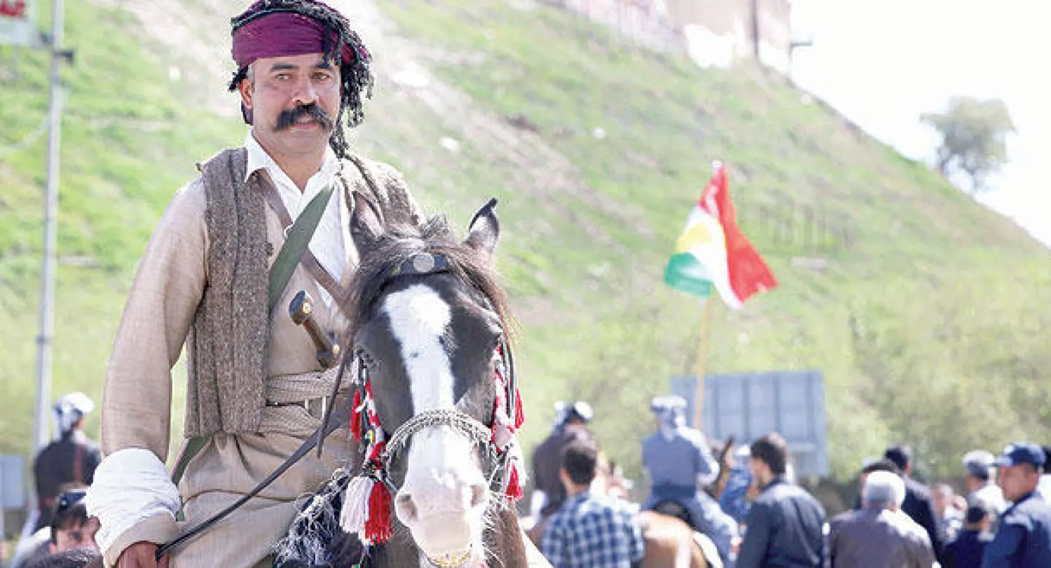 كردي باللباس التقليدي يمتطي حصانا خلال فعالية ضمن مهرجان «الحرية ونوروز» الذي تشهده أربيل هذه الأيام (أ.ف.ب)