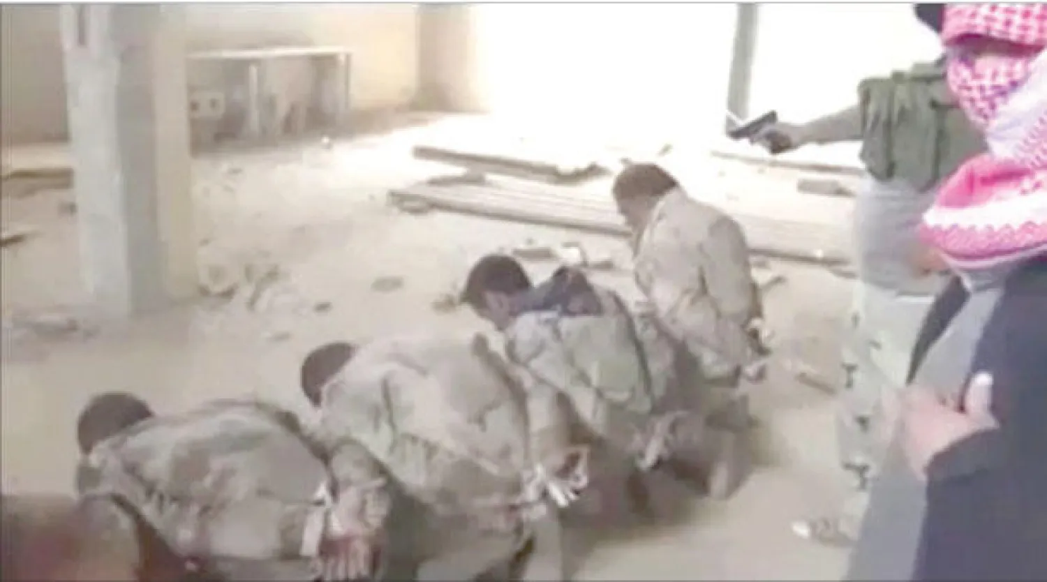 صورة بثها إعلام تنظيم القاعدة عبر مواقع التواصل الاجتماعي تعرض أحد عناصرها يقوم بإعدام جنود عراقيين في محيط الرمادي (رويترز)