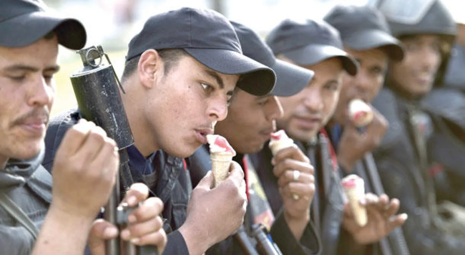 جنود مصريون يتناولون المثلجات في لحظات استراحة وسط اشتباكات مع طلاب تابعين لجماعة الإخوان أمام جامعة القاهرة أول من أمس (أ.ف.ب)