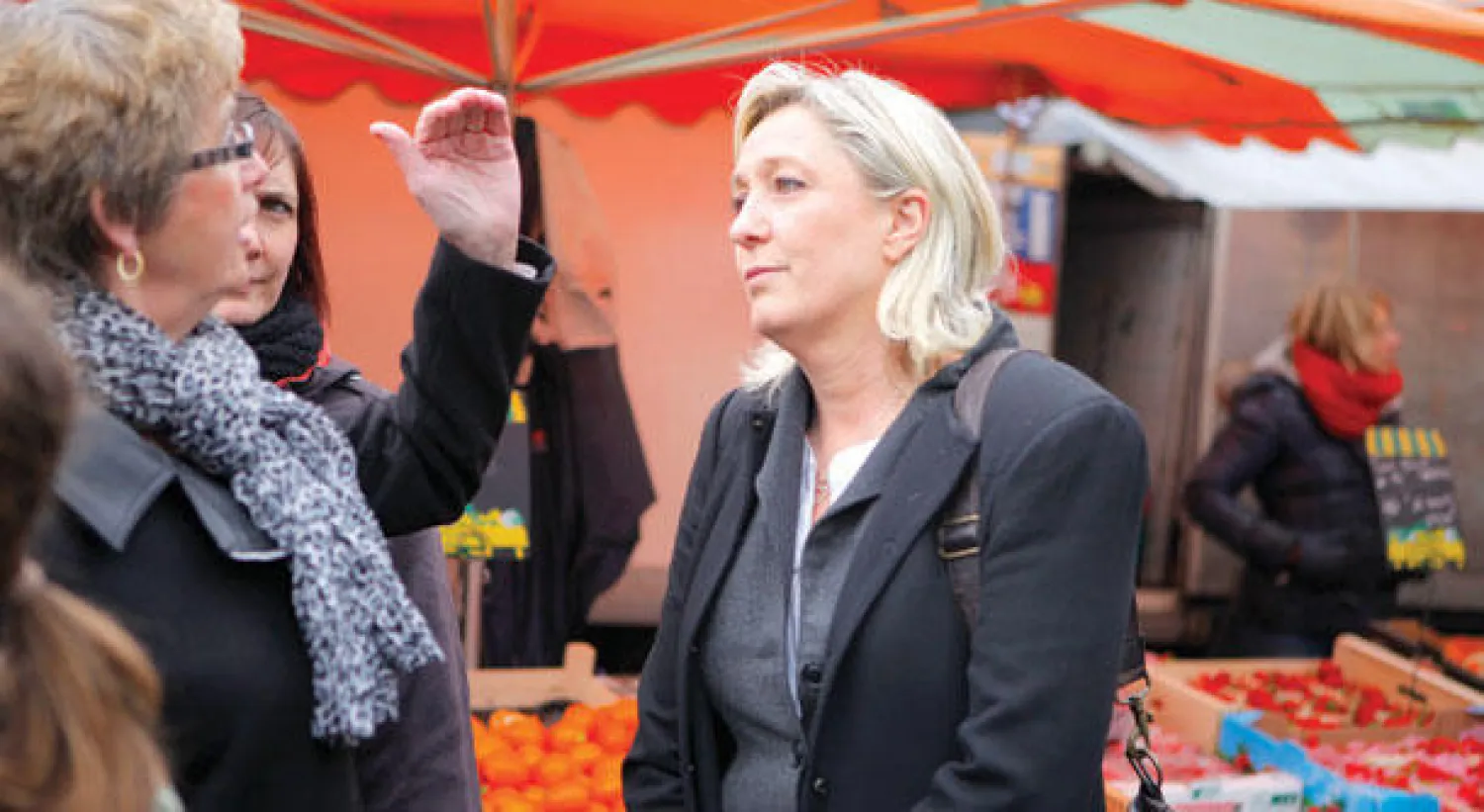 زعيمة اليمين المتطرف في فرنسا مارين لوبن (يمين) تتحدث إلى سكان في إطار حملة الانتخابات البلدية المقررة غدا، في مدينة هينان بومون الشمالية أمس (أ.ب)