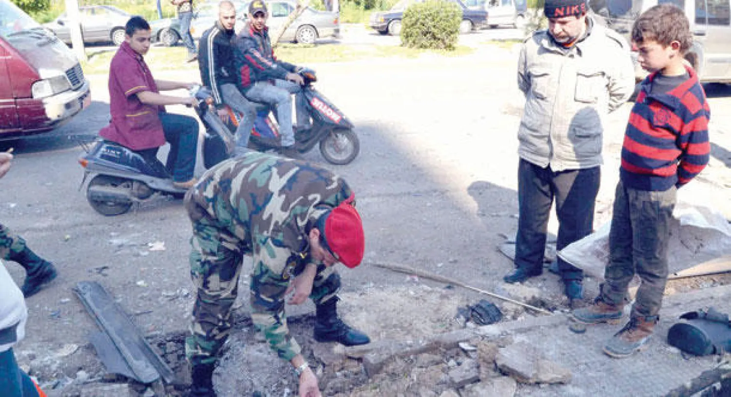 جندي لبناني يعاين أثر انفجار قنبلة في طرابلس أمس (رويترز)