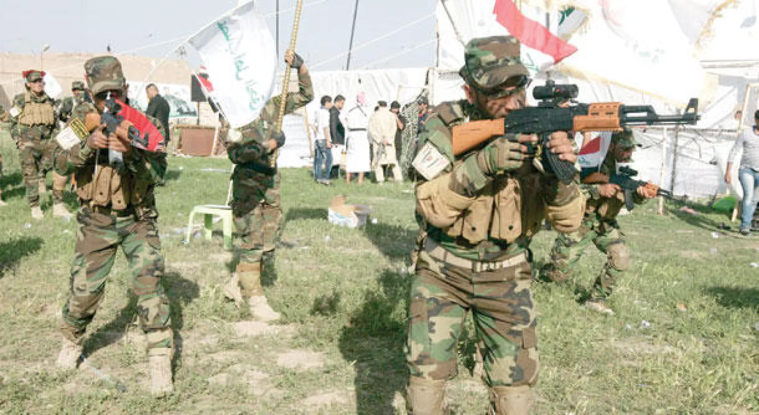 ميليشيا «عصائب أهل الحق» الشيعية التي تقاتل في سوريا دفاعا عن نظام الرئيس بشار الأسد تستعرض في كربلاء بصورة علنية أمس (رويترز)