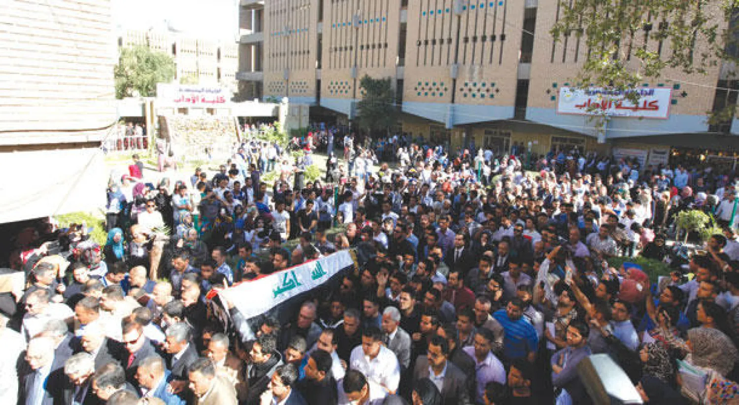 طلاب يشاركون في مسيرة تنديدا بمقتل بديوي في جامعة المستنصرية في بغداد أمس (رويترز)