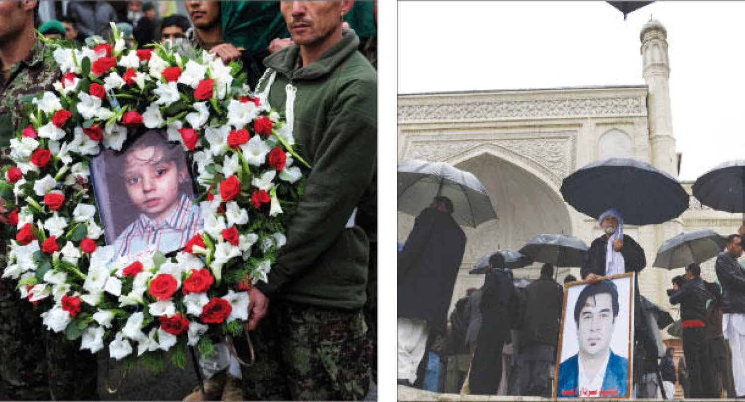 عائلة وأقارب الصحافي الأفغاني سردار أحمد يحتشدون أمام مسجد عيد غاه في العاصمة كابل في انتظار خروج جثمانه قبل دفنه في مقبرة العائلة أمس (أ.ف.ب)  -  جنود أفغان يحملون صورة عمر نجل الصحافي الأفغاني سردار أحمد الذي قتل أيضا مع والده في هجوم لطالبان (أ.ف.ب)