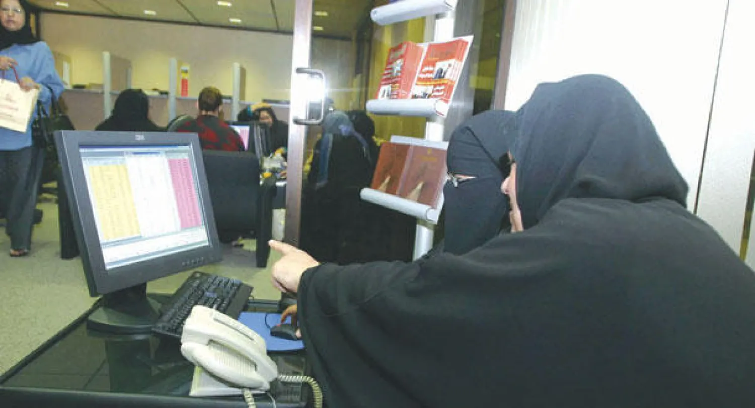 سيدتان تتابعان تداولات الأسهم الكويتية (رويترز)