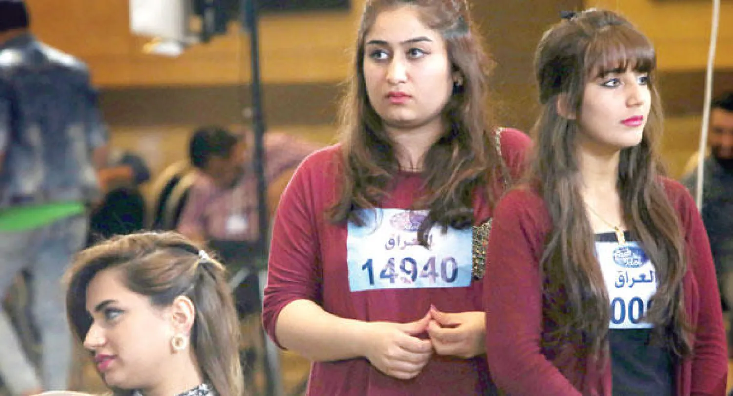 شابتان عراقيتان تنتظران دورهما للوقوف أمام لجنة اختبار برنامج (عرب آيدول) في أربيل (أ.ف.ب)