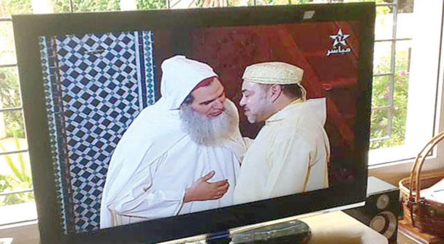 صورة تلفزيونية للملك محمد السادس وهو يتحدث مع خطيب مسجد طارق بن زياد في طنجة  الشيخ السلفي محمد الفزازي  المفرج عنه بعفو ملكي (الشرق الاوسط)
