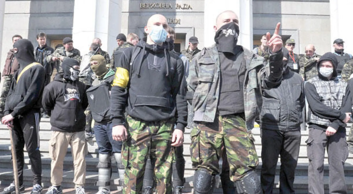 مؤيدون لحركة «برافي سيكتور» اليمينية المتطرفة يتظاهرون أمام البرلمان في كييف أمس، مطالبين باستقالة وزير الداخلية غداة مقتل أحد قادة الحركة برصاص الشرطة (أ.ف.ب)