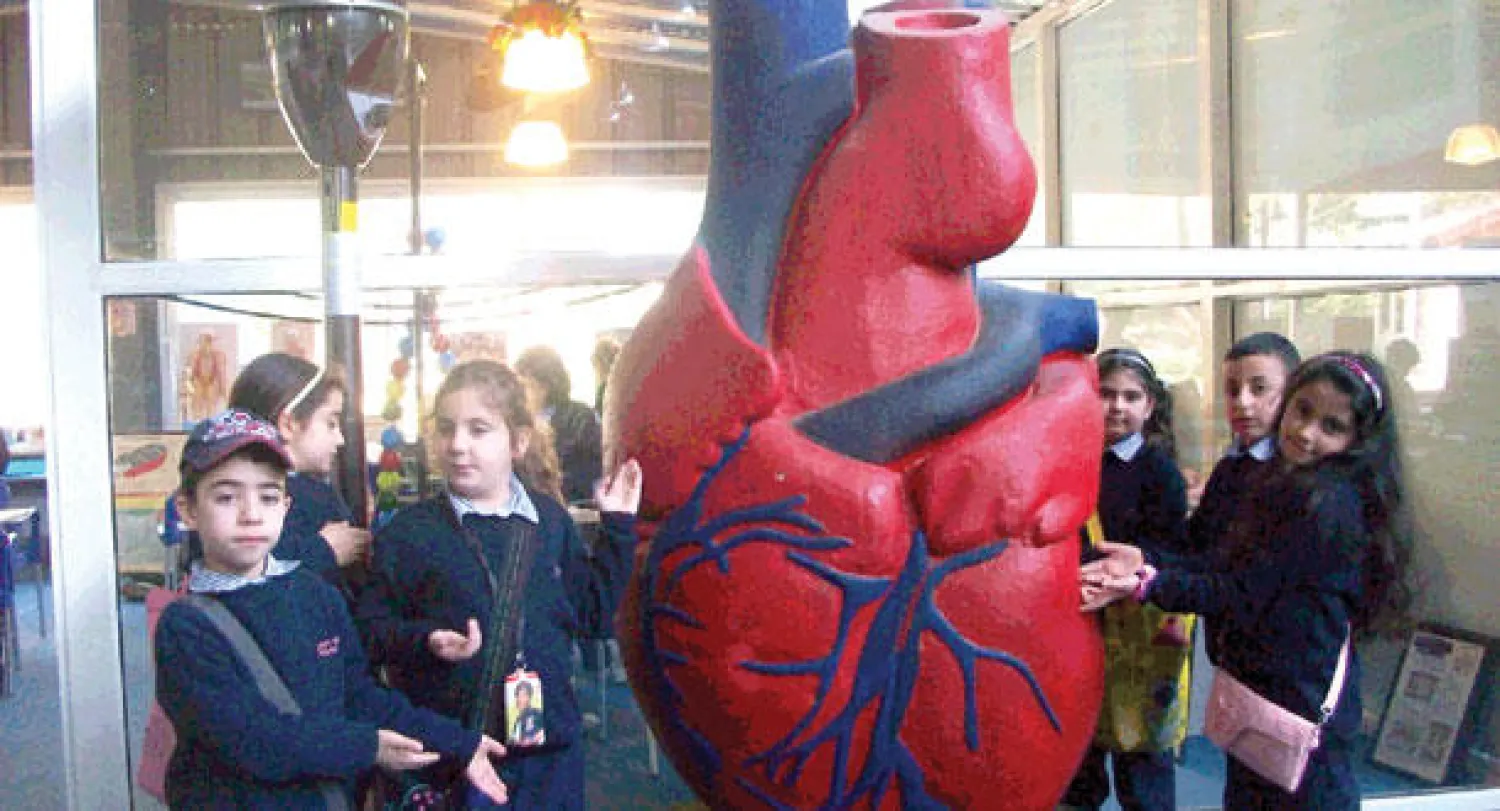 مجموعة من الأطفال يحيطون بمجسم للقلب في القرية العلمية ({الشرق الأوسط})