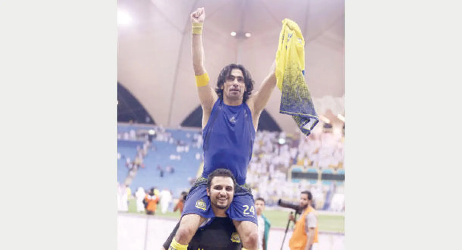 حسين عبد الغني محمولا على كتف زميله الحارس عبد الله العنزي (تصوير: عبد العزيز النومان)