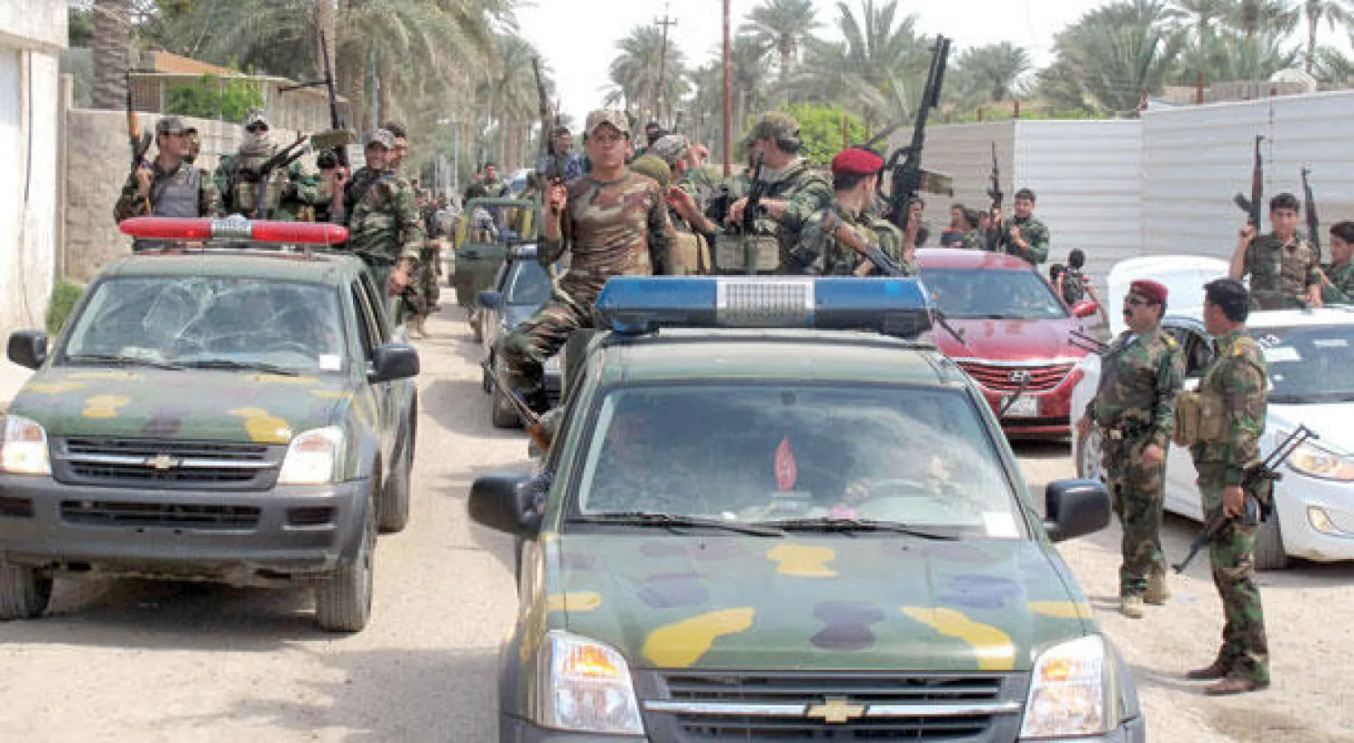 قوة عراقية من متطوعي أبناء العشائر استعرضت عسكريا أمس وسط مدينة الرمادي احتفالا ببسط سيطرتها على جميع أنحائها (أ.ف.ب)