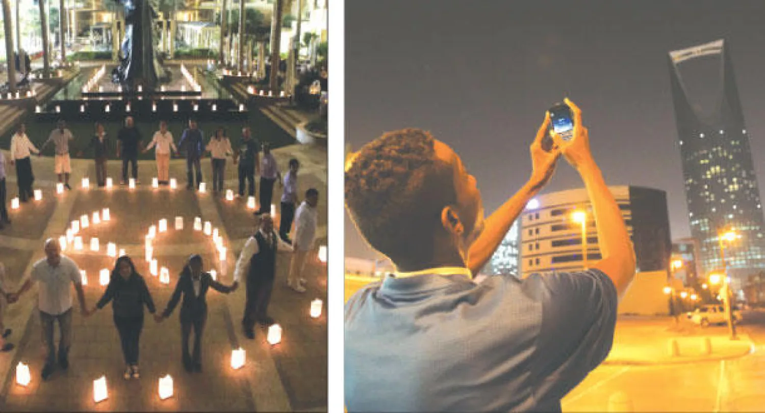 التقاط صورة لبرج المملكة بالعاصمة الرياض في مبادرة ساعة الأرض (أ.ب)  -  عاملون في «جميرا بيتش» في تونس يشكلون بالشموع الرقم «60» (أ.ف.ب)