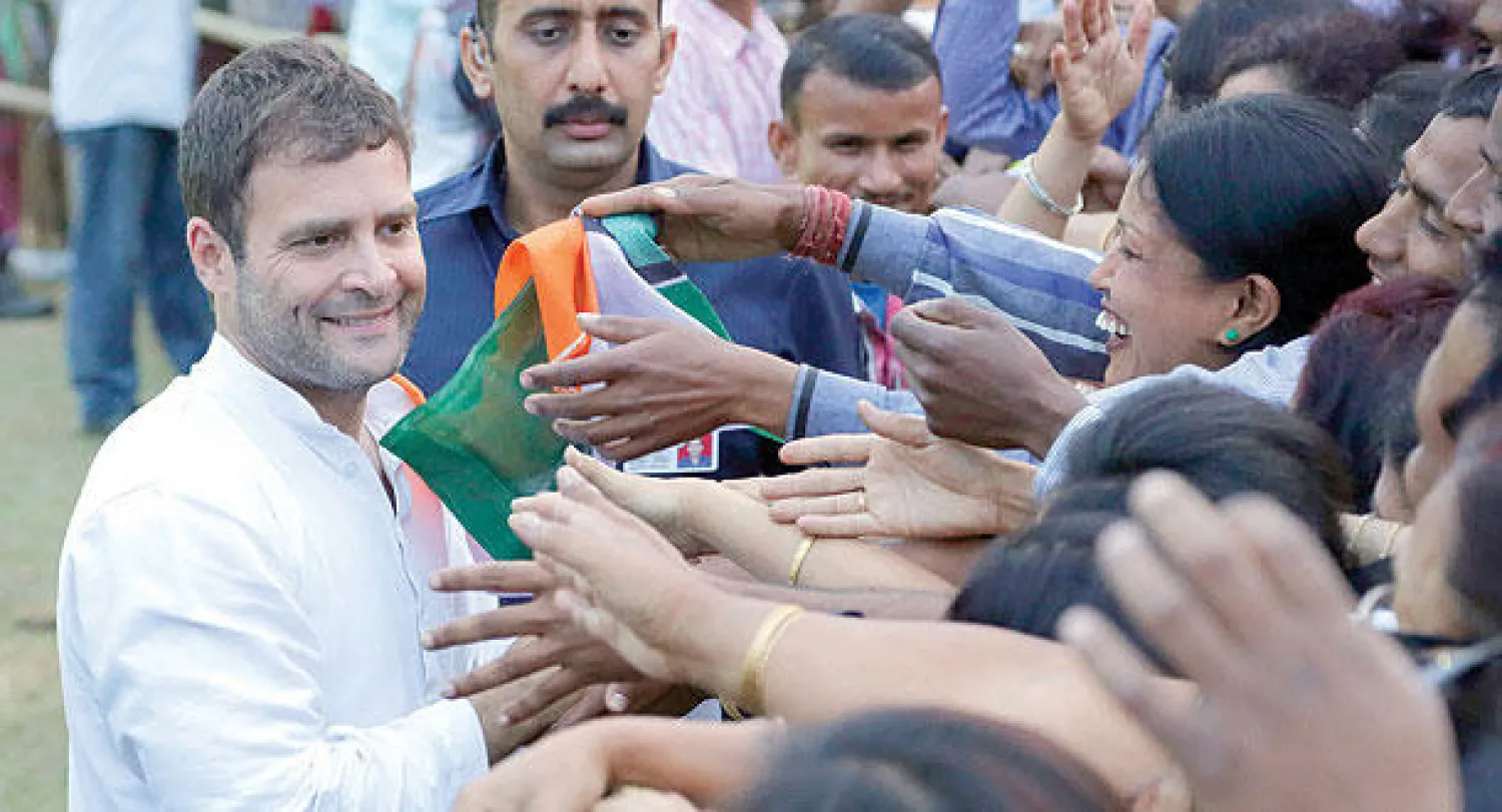 راهول غاندي يصافح مناصريه خلال تجمع انتخابي في مدينة ديبروغاره في ولاية أسام الشمالية (أ.ب)