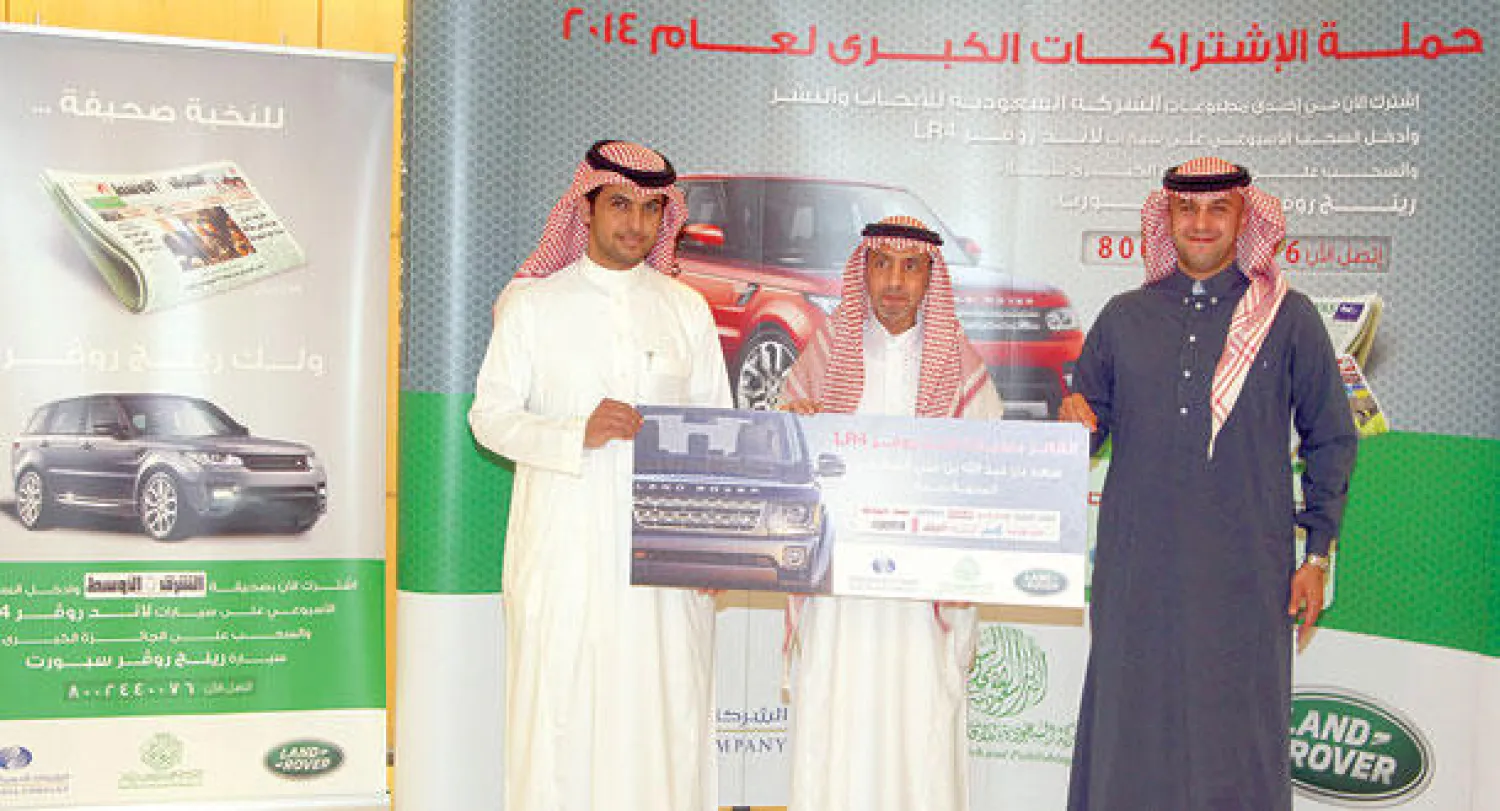 مسؤولان من {الأبحاث والنشر} لدى تسليم الفائز جائزة الأسبوع السادس من حملة الاشتراكات الكبرى