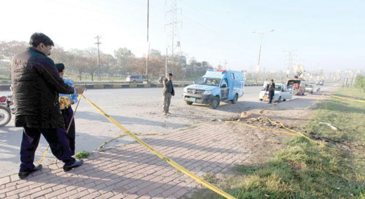 الشرطة تحقق في موقع الانفجار الذي استهدف موكب مشرف بمدينة روالبندي أمس (رويترز)