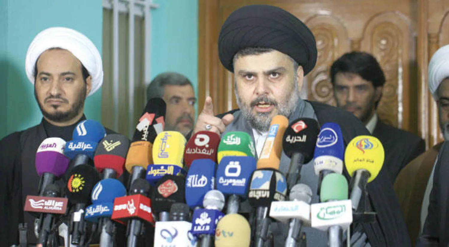 مقتدى الصدر في مؤتمره الصحافي وإلى يمينه النائب المبعد عن الترشيحات صباح الساعدي في النجف (أ.ف.ب)