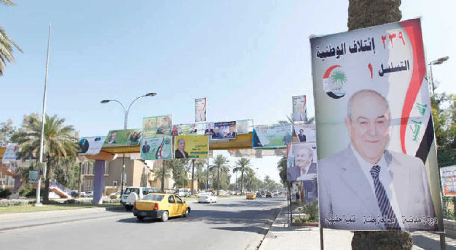 ملصق دعائي للدكتور إياد علاوي رئيس «ائتلاف الوطنية» في أحد شوارع بغداد (رويترز)