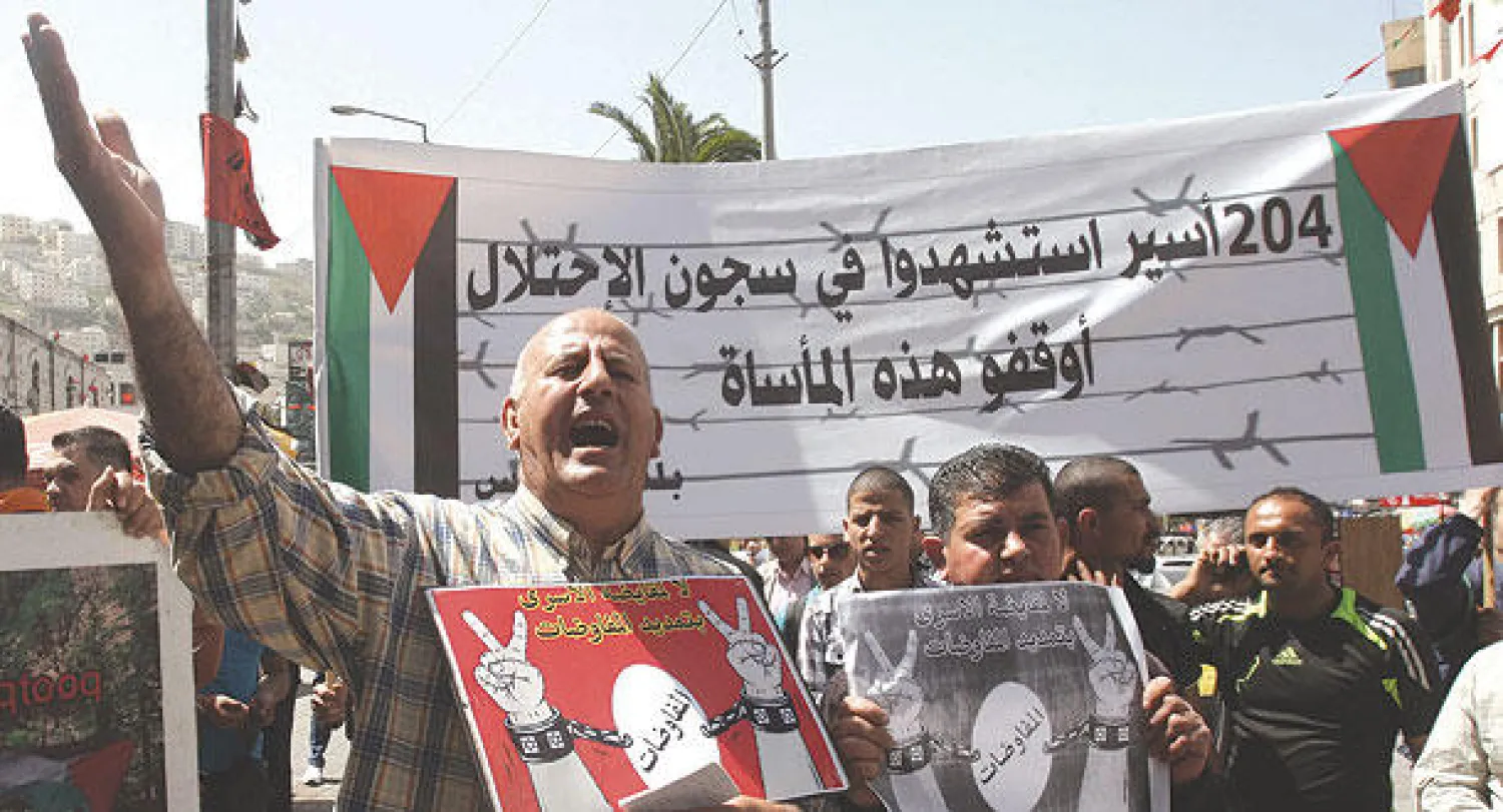 فلسطينيون يتظاهرون للمطالبة بإطلاق سراح الدفعة الرابعة من الأسرى ورفض تمديد مفاوضات السلام بمدينة نابلس في الضفة الغربية أمس (رويترز)