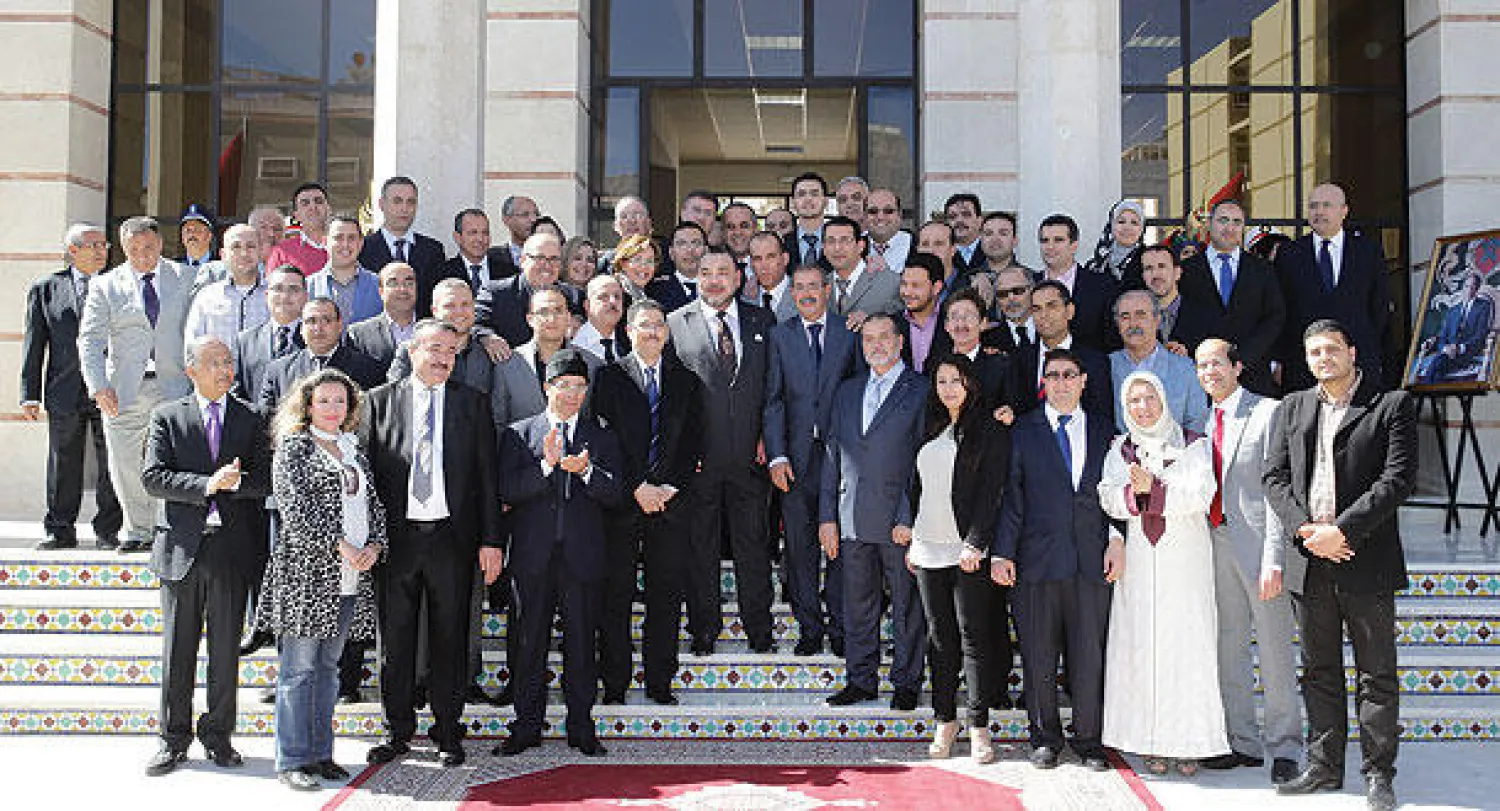 العاهل المغربي في صورة تذكارية مع مجموعة من الصحافيين المغاربة عقب تدشينه «بيت الصحافة» في طنجة أمس (ماب)